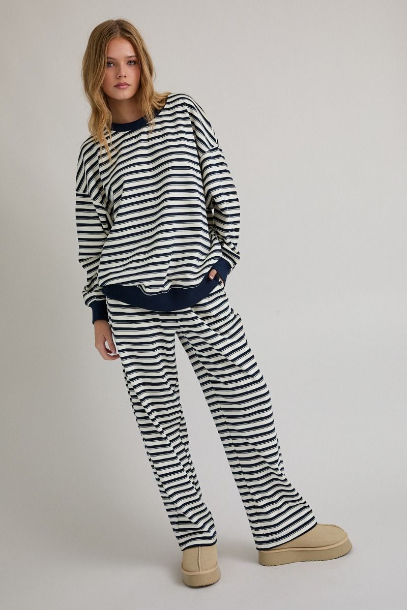 Woman wearing a black and white striped outfit on a plain background