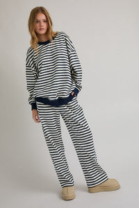 Woman wearing a black and white striped outfit on a plain background