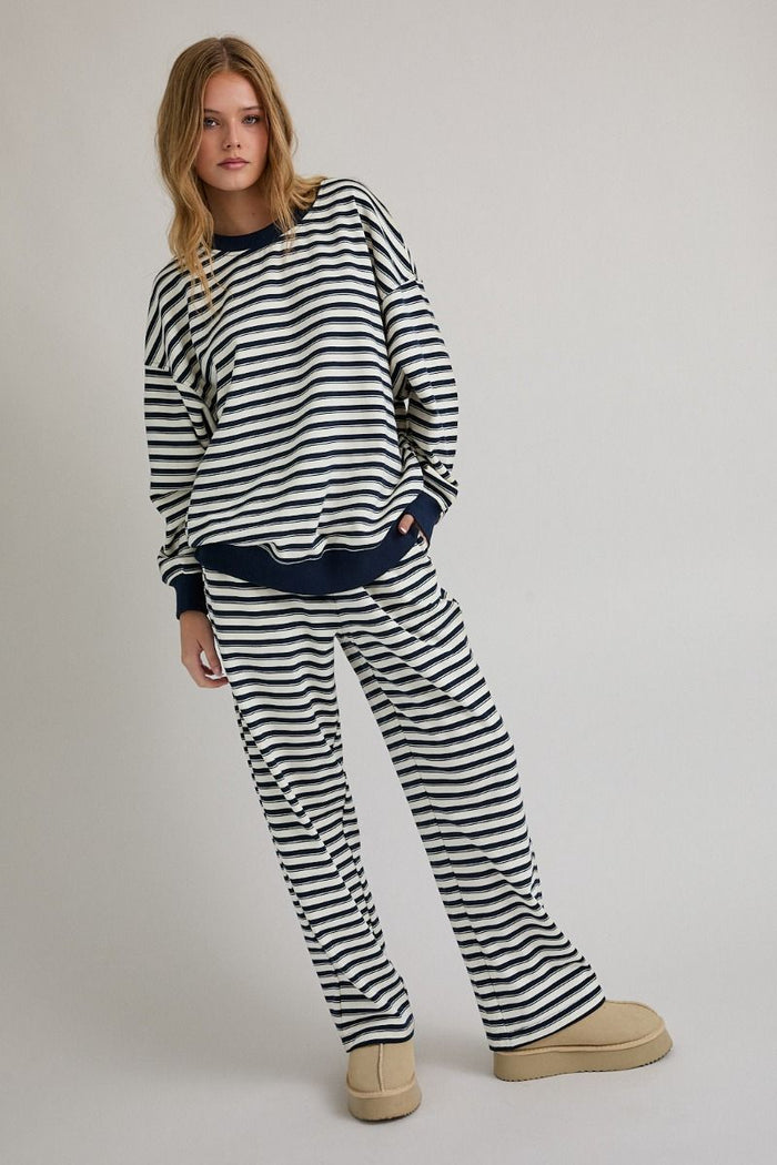 Woman wearing a black and white striped outfit on a plain background