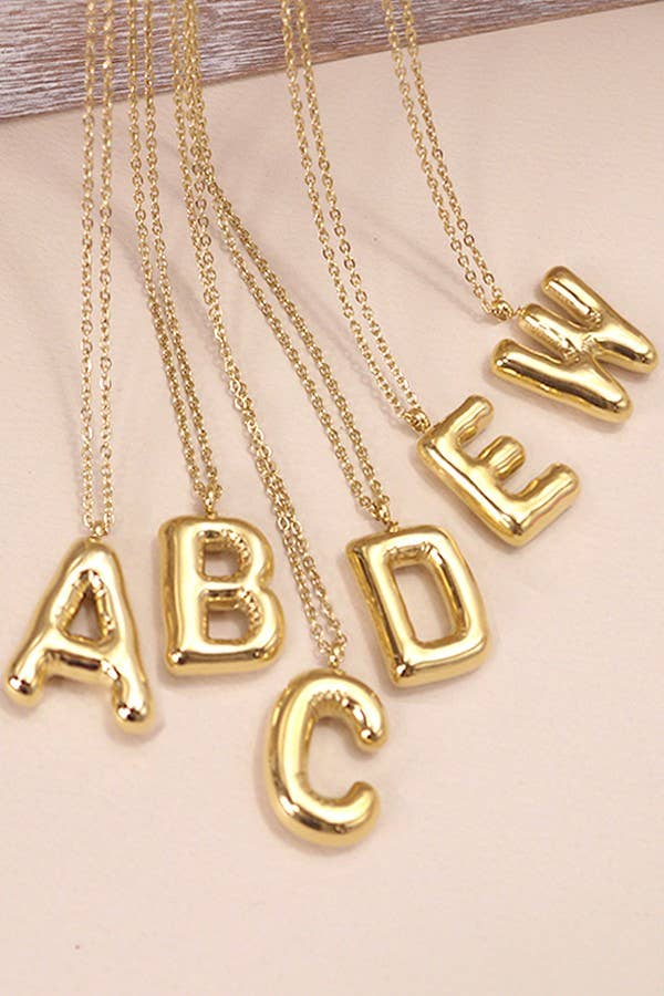 A gold-colored stainless steel necklace with initial letter charms in a bubble balloon design.